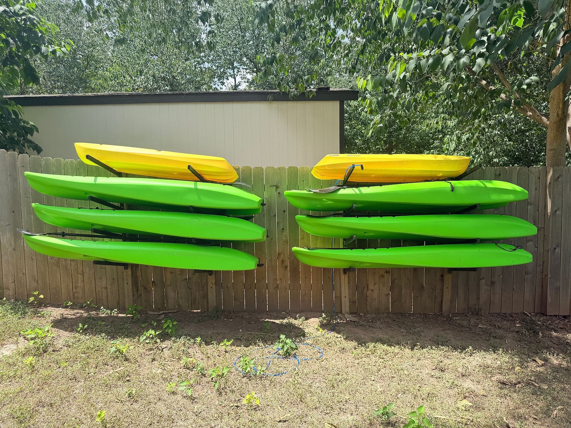 Kayaks and paddleboards stored on the fence at River Bend Bliss