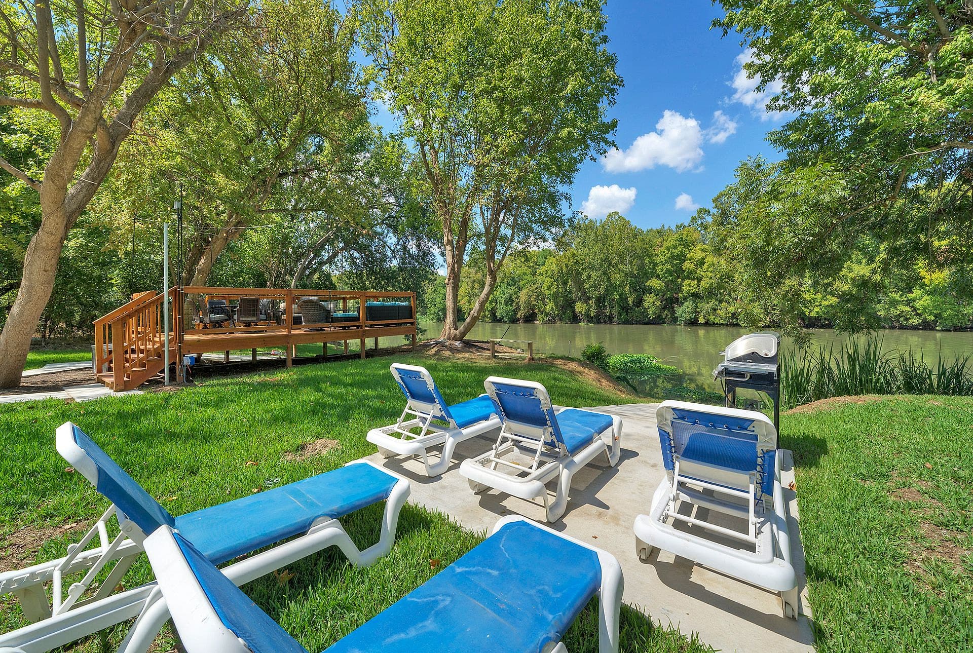 Blue loungers on the lawn leading to the river viewing deck