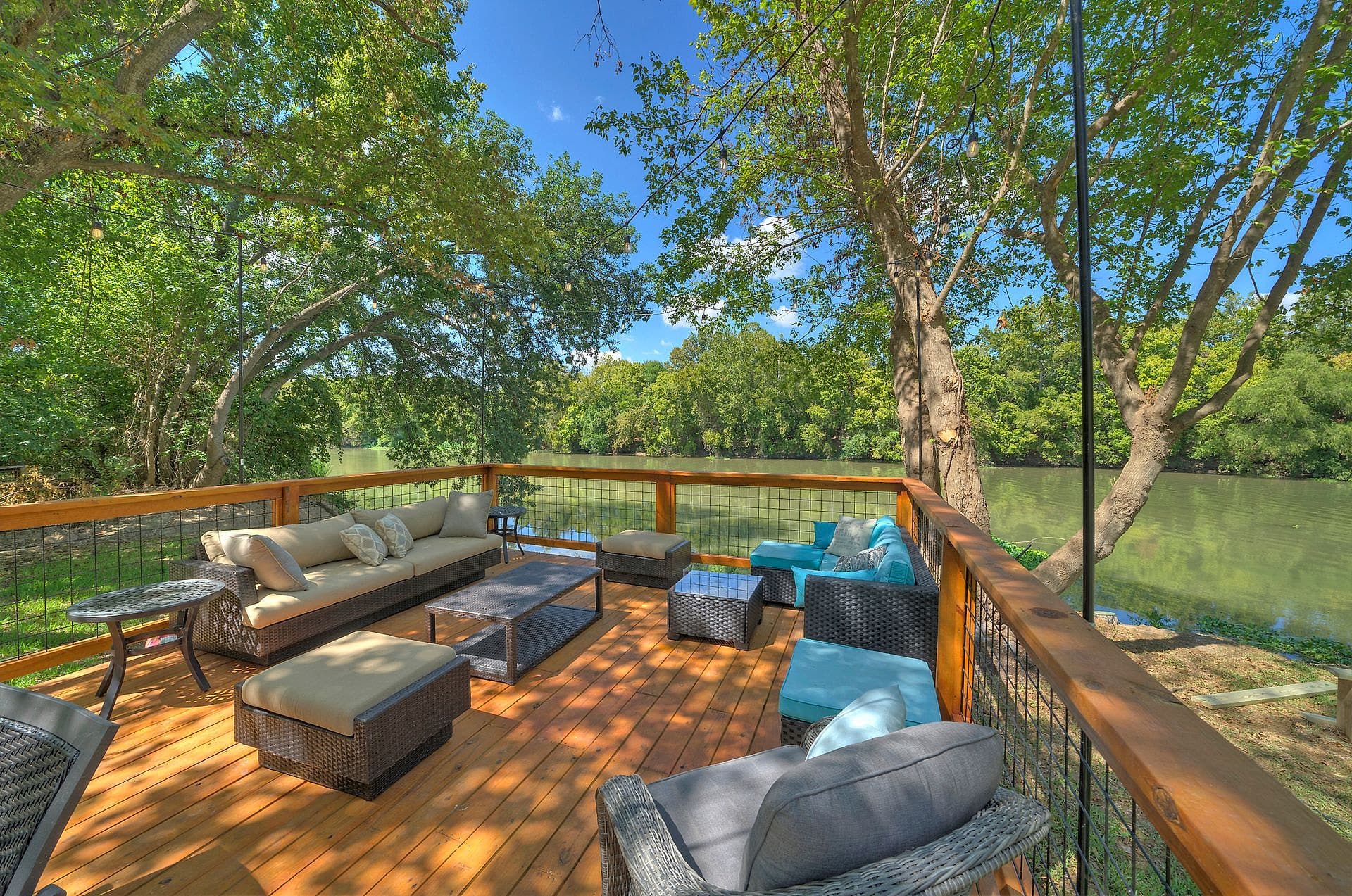 Outdoor sofas on the river viewing deck under shade trees