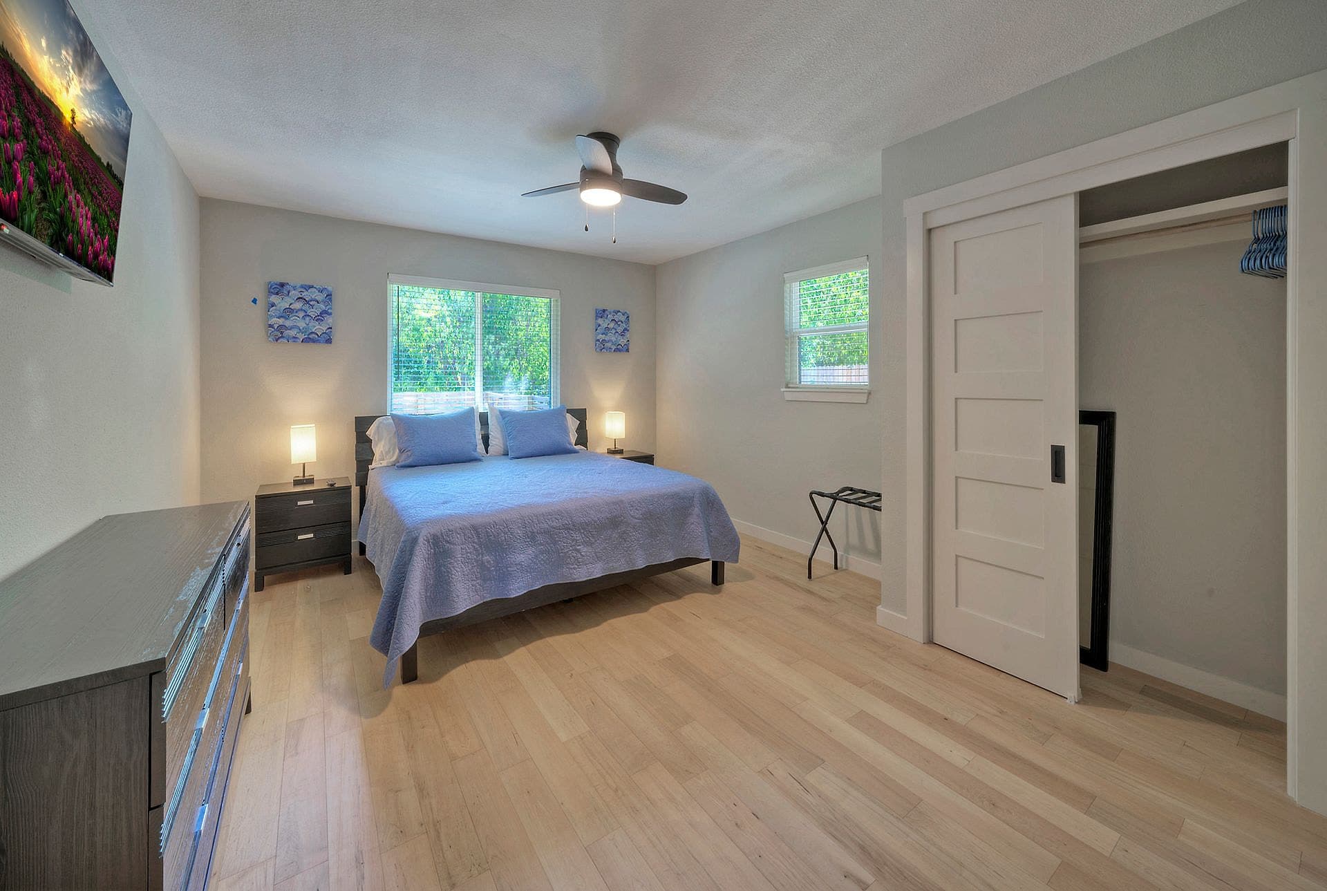 Bedroom with a large bed, ceiling fan and TV in the River Bend Bliss house
