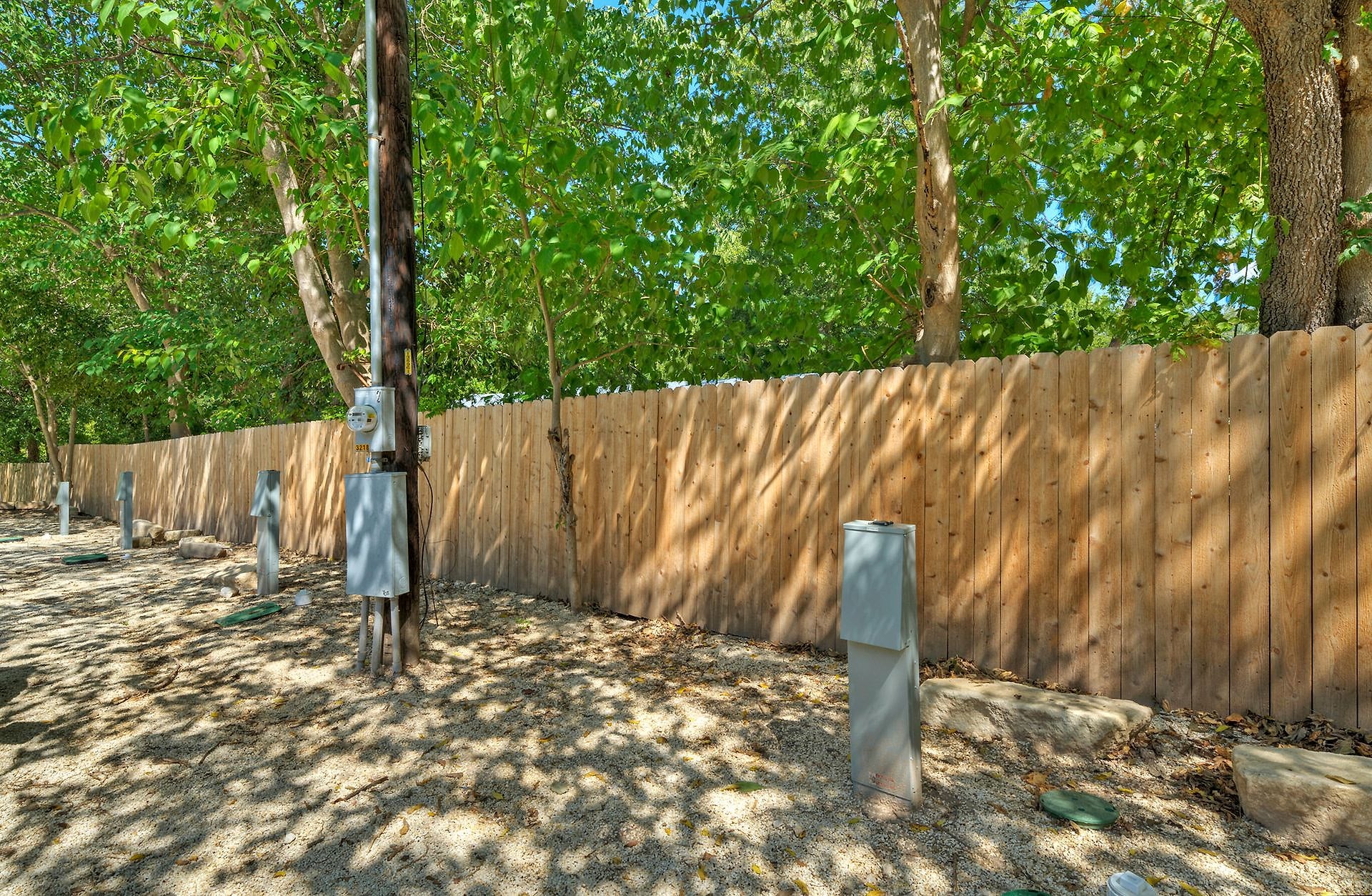 Shaded back-in RV site with hookup pedestal at River Bend Bliss RV park